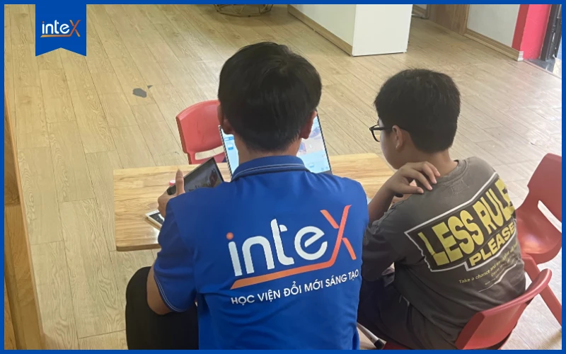 Thầy giáo đang hướng dẫn học sinh cấp 2 thực hành lập trình Scratch