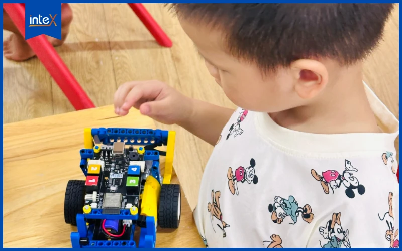 Bé trai đang điều khiển robot tại lớp học lập trình dành cho trẻ em